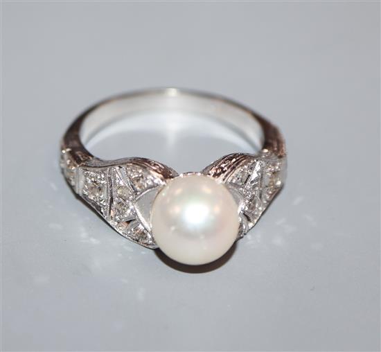 A modern 750 white metal, cultured pearl and diamond set dress ring, with pierced shoulders, size R/S.